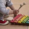 Niño jugando con xilófono de madera