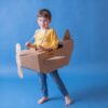 Niño con avión de cartón