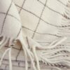 Detalle manta decorativa para cama de cuadros blanca