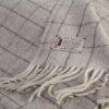 Detalle manta decorativa para cama de cuadros gris