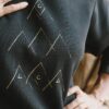 Detalle estampado montañas sudadera negra ecológica