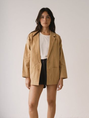 Americana de sarga en color mostaza de algodón orgánico combinada con pantalón corto negro.