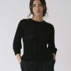 Jersey calado negro de algodón orgánico con textura vertical y cuello redondo para mujer