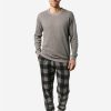 Hombre con pijama largo de algodón orgánico, camiseta gris y pantalón a cuadros.