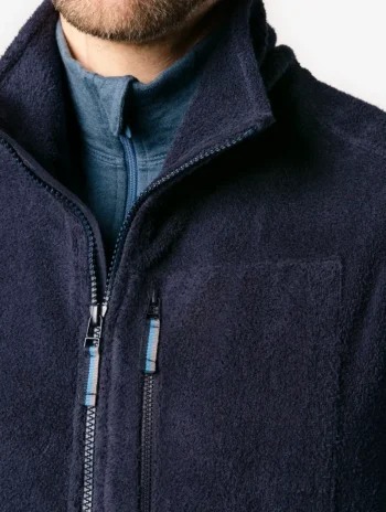 Detalle de chaleco de forro polar azul marino con cuello alto y bolsillos con cremallera