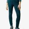 Mujer con pantalón ajustado verde azulado y zapatillas de senderismo grises